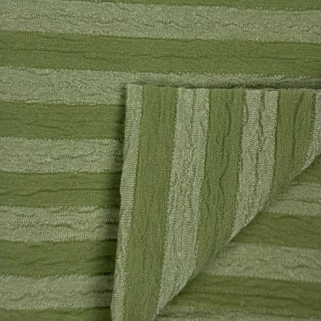 Close-up of green textured fabric with a folded edge