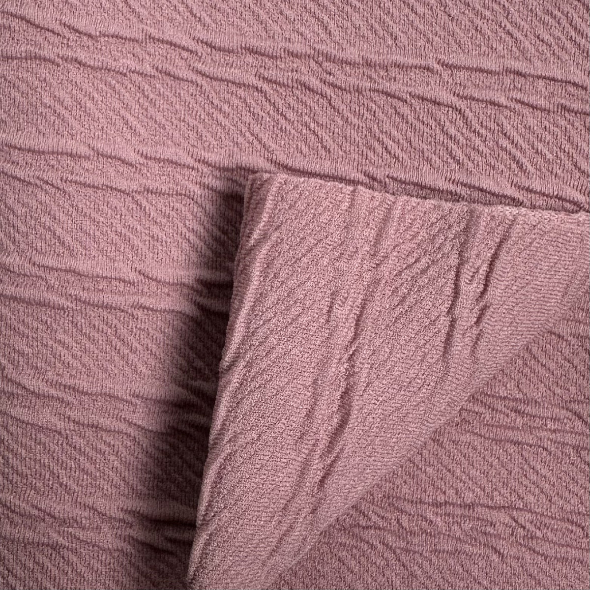 Close-up of textured pink fabric with a subtle pattern