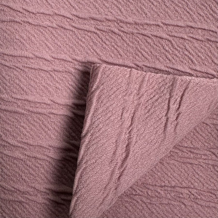 Close-up of textured pink fabric with a subtle pattern