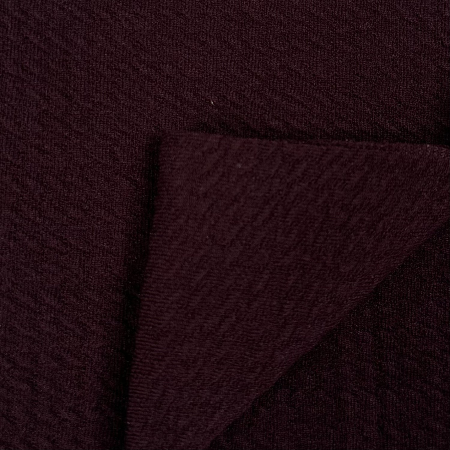 Close-up of dark brown fabric with a textured pattern