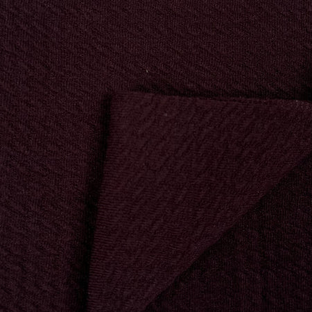 Close-up of dark brown fabric with a textured pattern