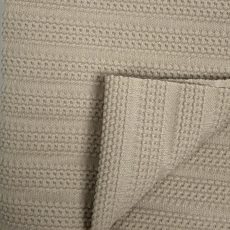 Close-up of textured beige fabric with a waffle pattern