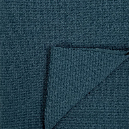 Close-up of textured teal fabric with a corner folded over