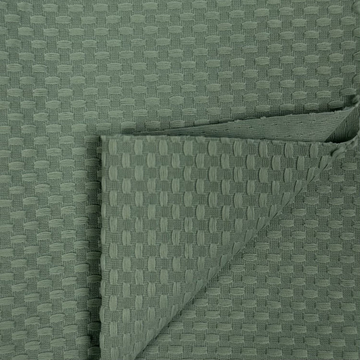 Folded green fabric with a textured pattern on a matching background