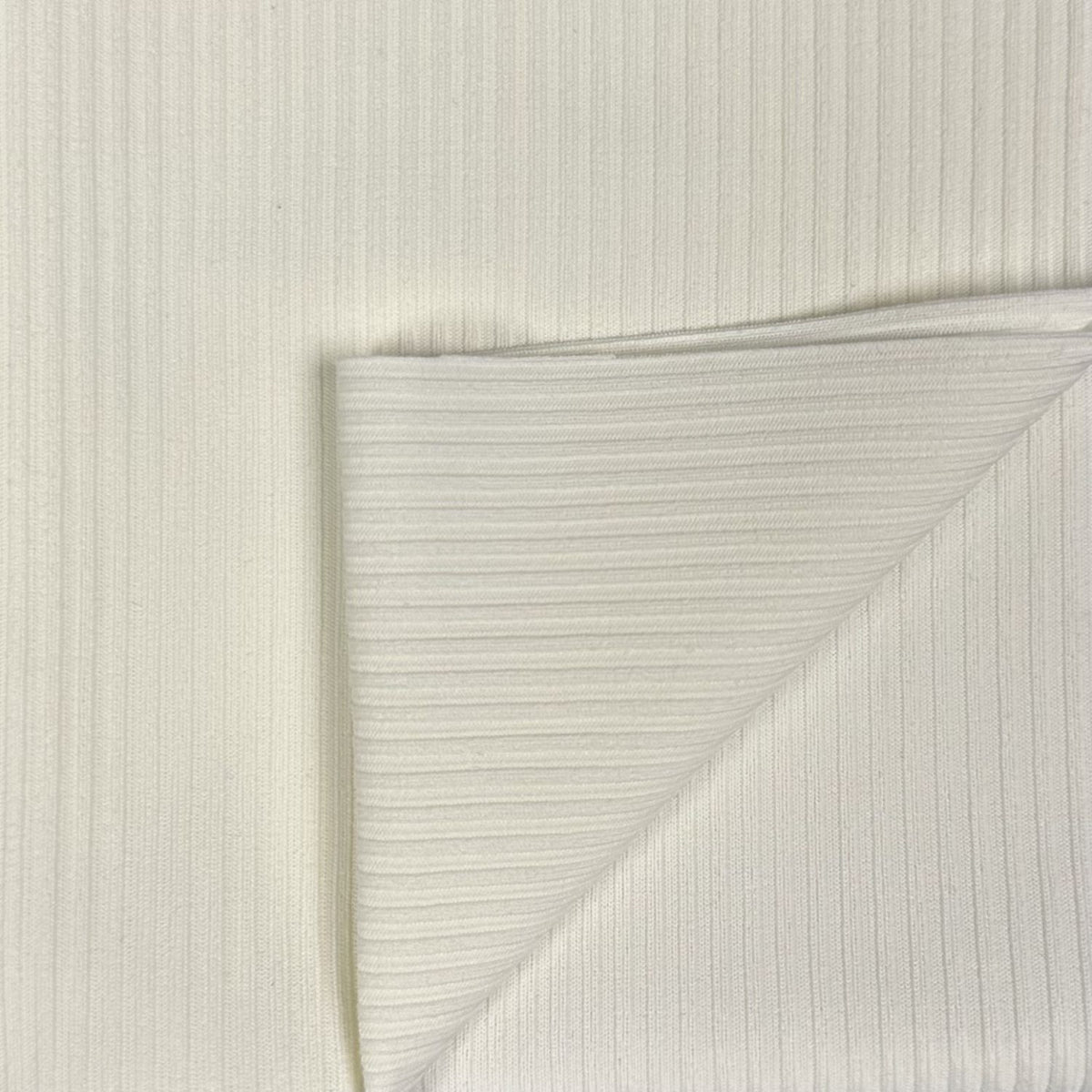 Close-up of textured white paper with a diagonal crease on a light gray background