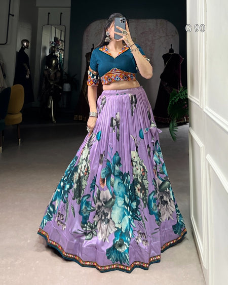 Woman taking a mirror selfie wearing a colorful outfit with a purple skirt and blue top.