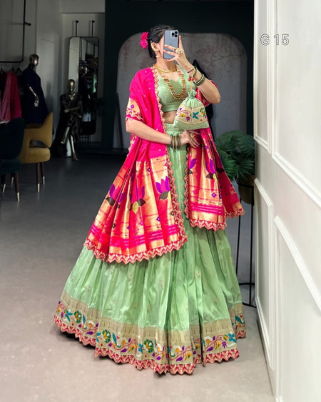 Person wearing a green traditional outfit with a pink dupatta in a room.