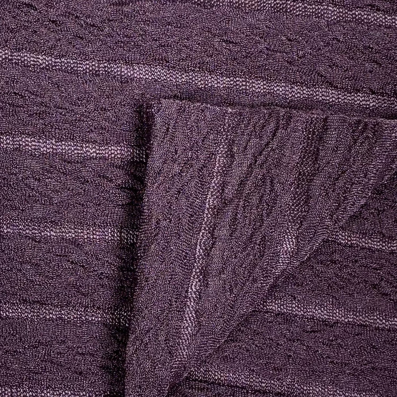 Close-up of textured purple fabric with a folded edge
