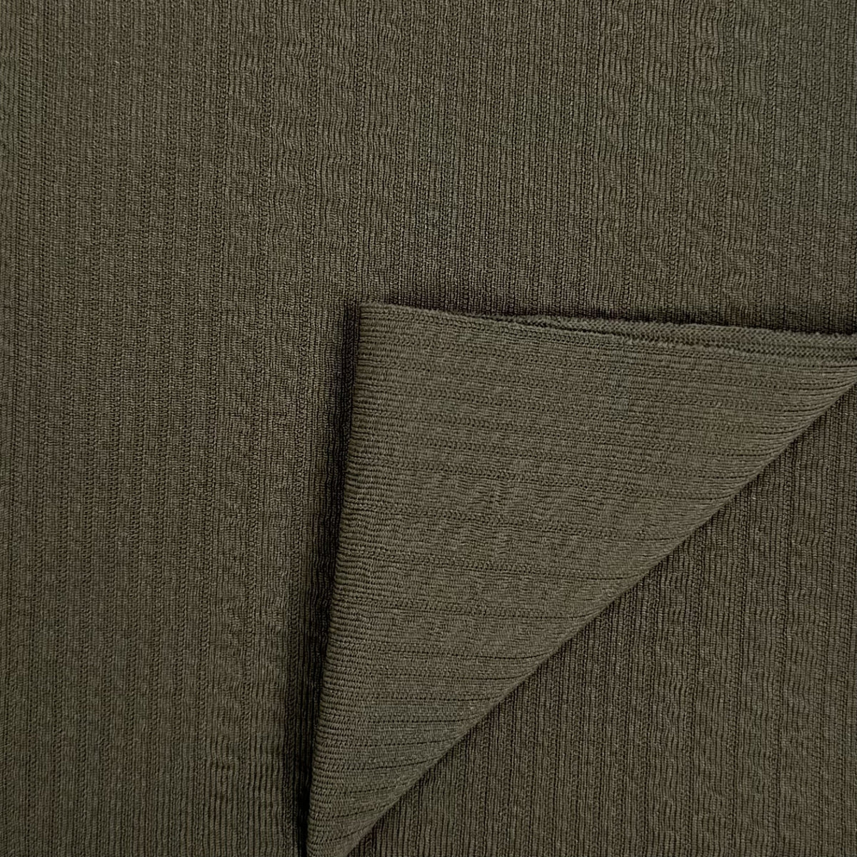 Close-up of dark green fabric with a textured pattern