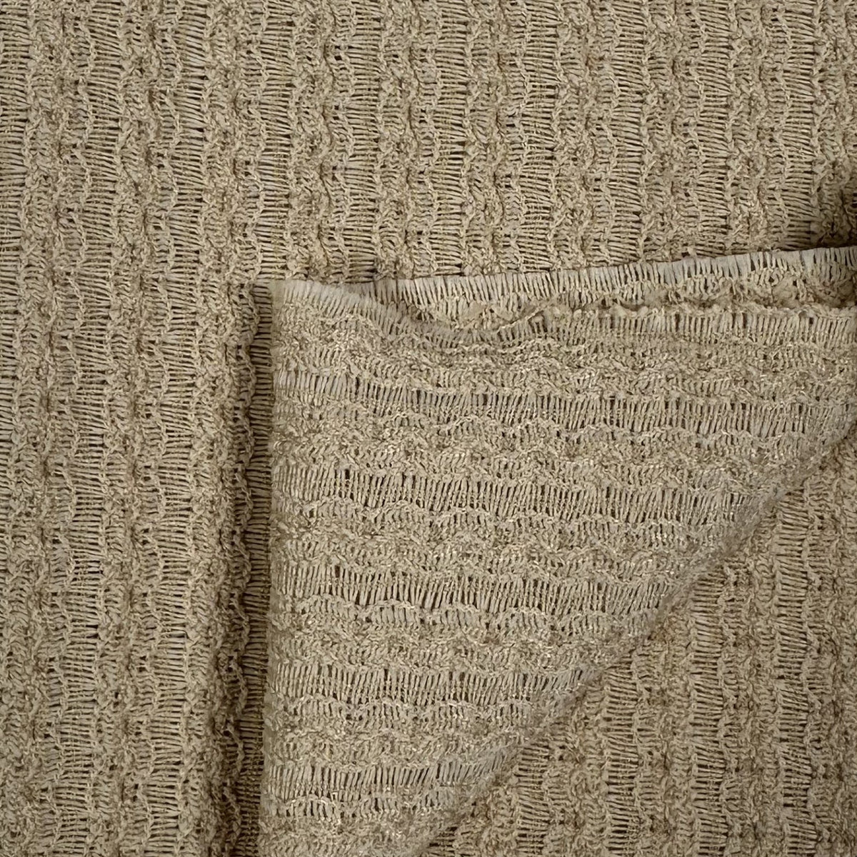 Close-up of beige textured fabric with a pocket detail
