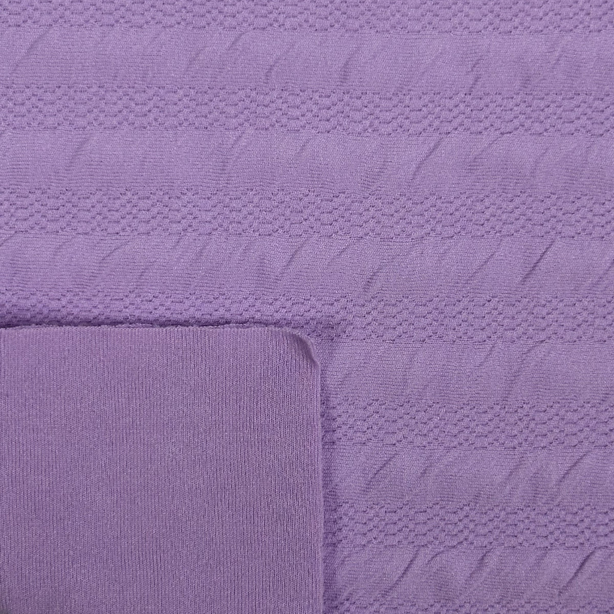 Close-up of a textured purple fabric with a folded corner.