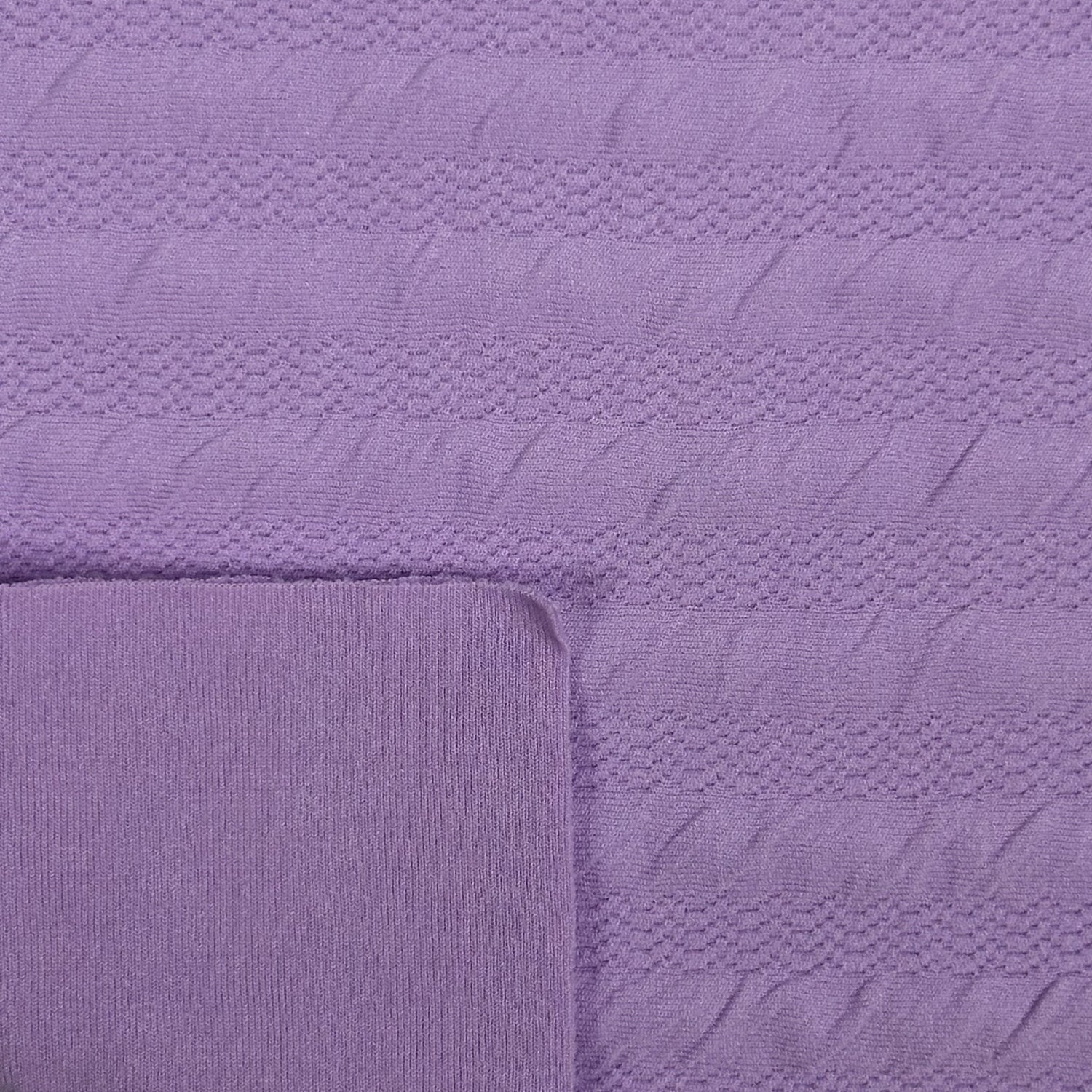 Close-up of a textured purple fabric with a folded corner.