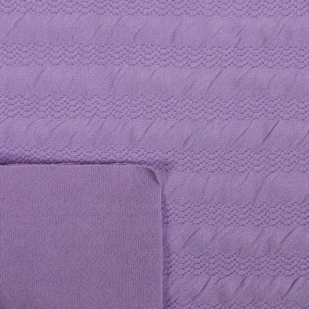 Close-up of a textured purple fabric with a folded corner.
