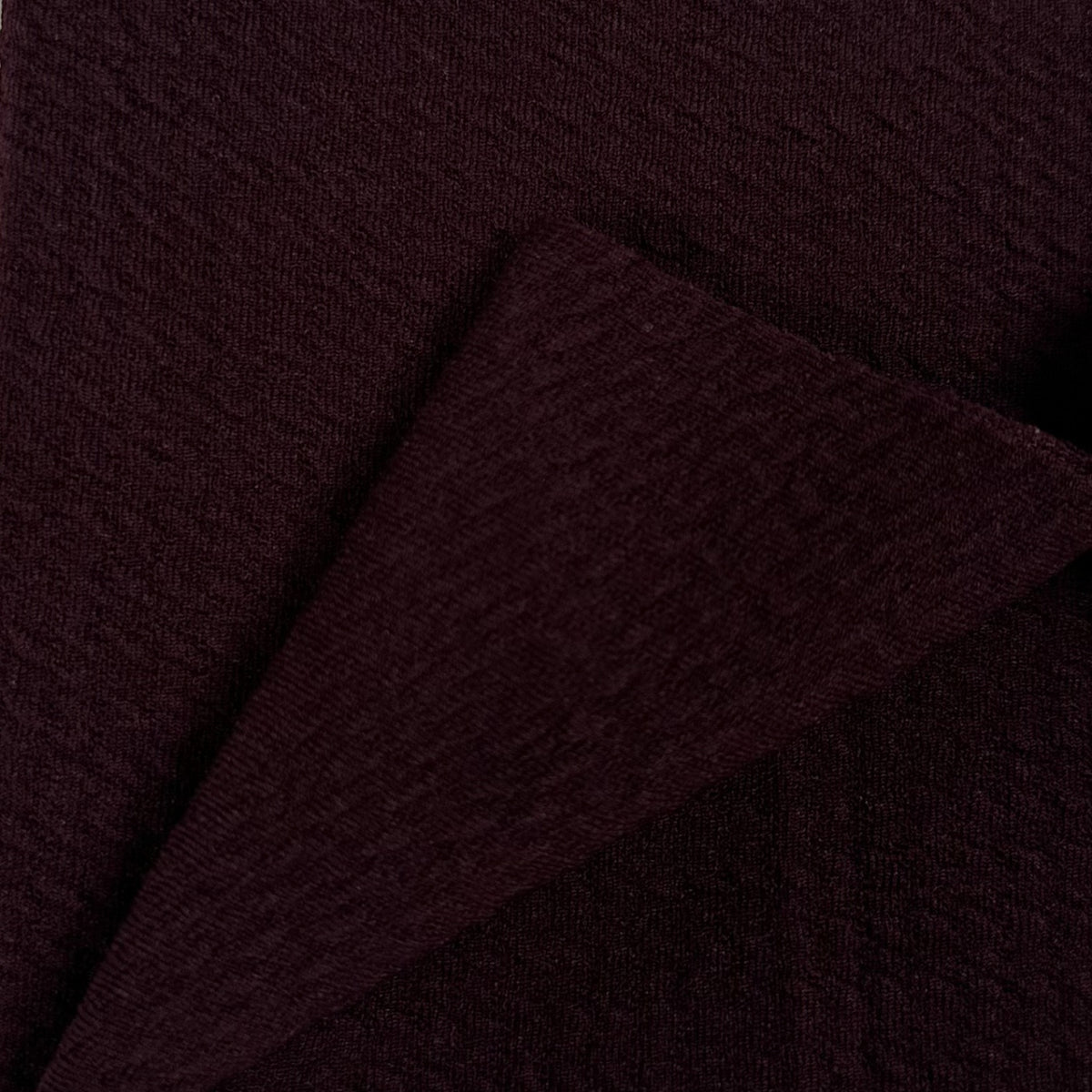 Close-up of dark brown fabric with a subtle texture