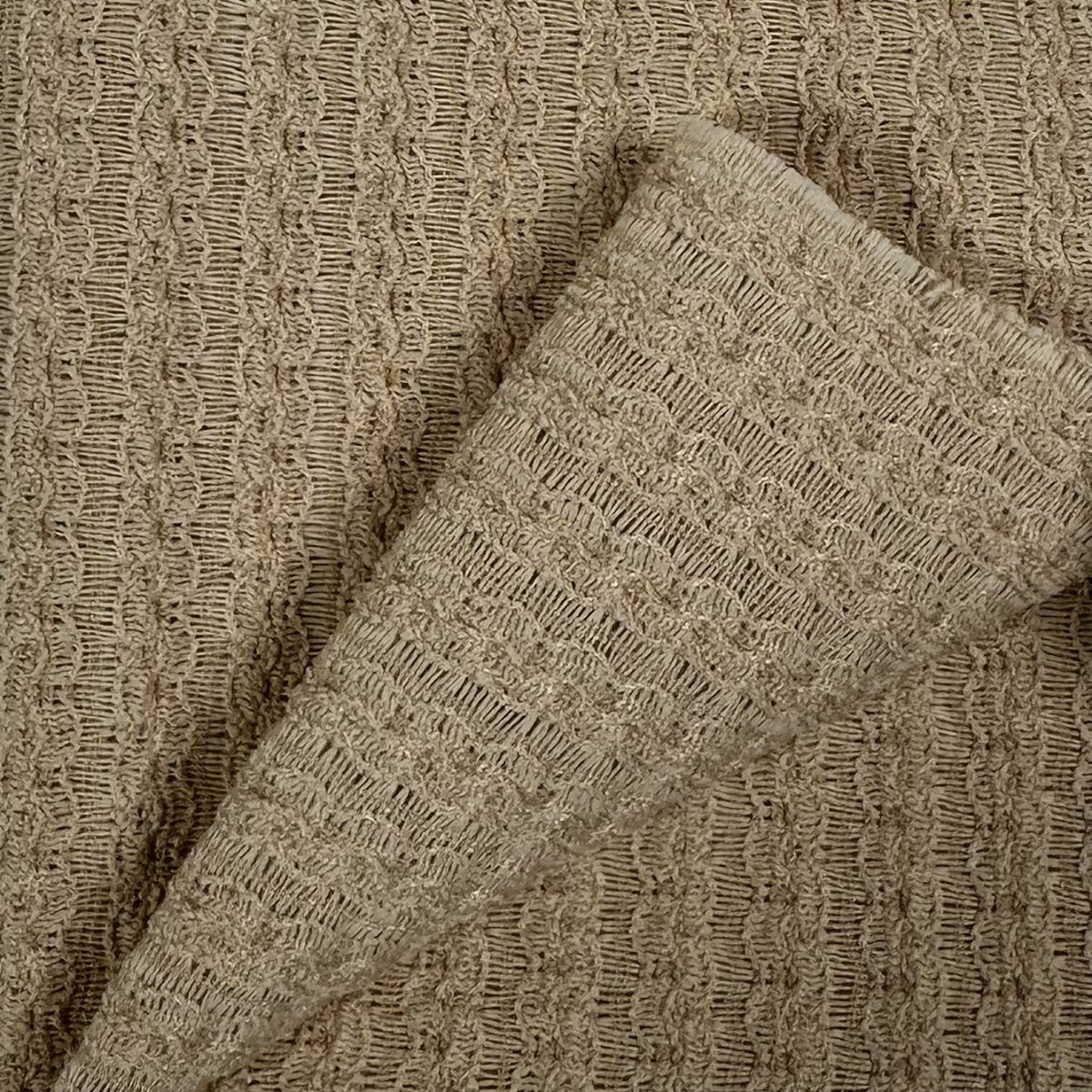 Close-up of textured beige fabric with a subtle pattern