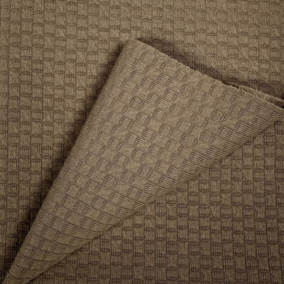 Brown textured fabric with a folded corner on a matching background