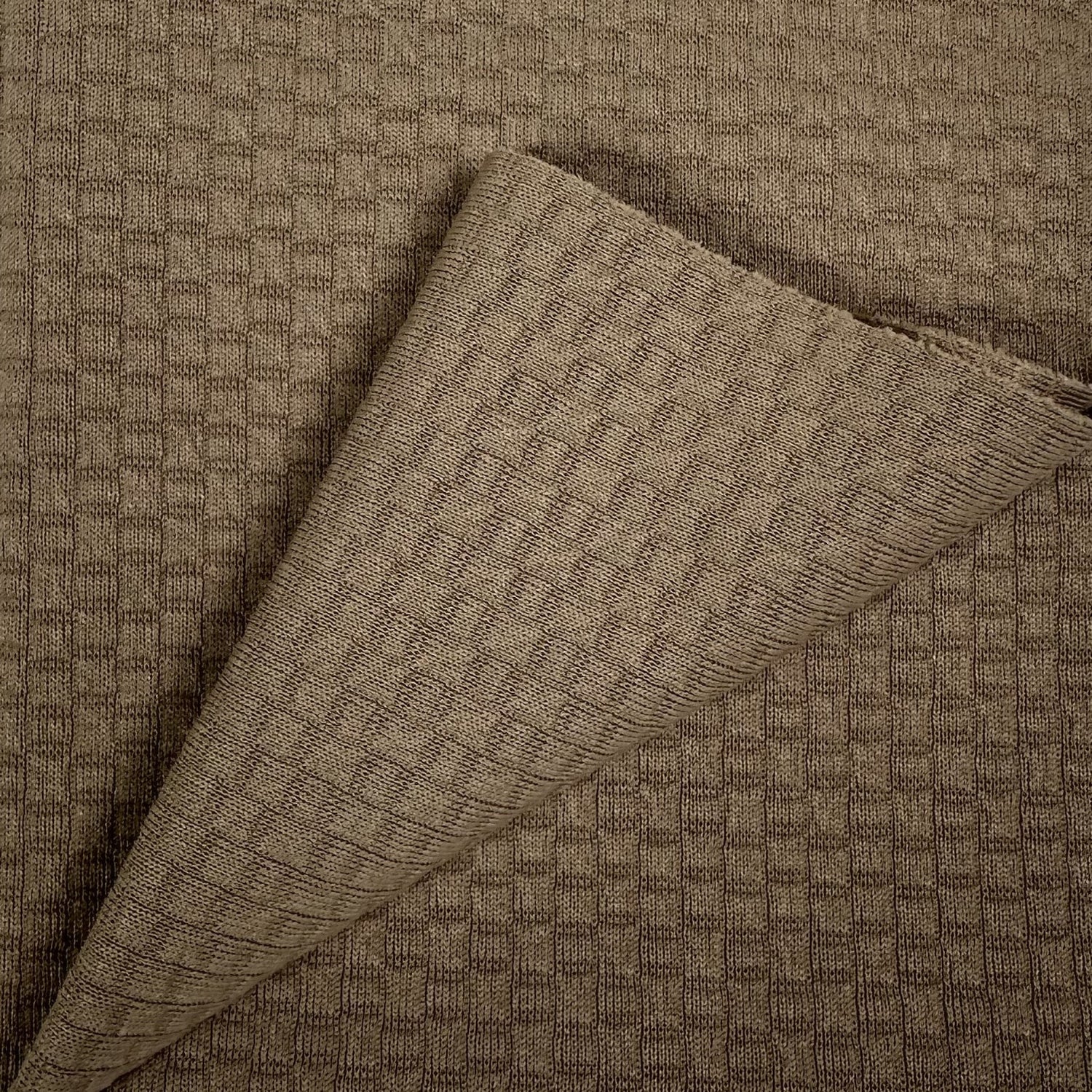 Brown textured fabric with a folded corner on a matching background