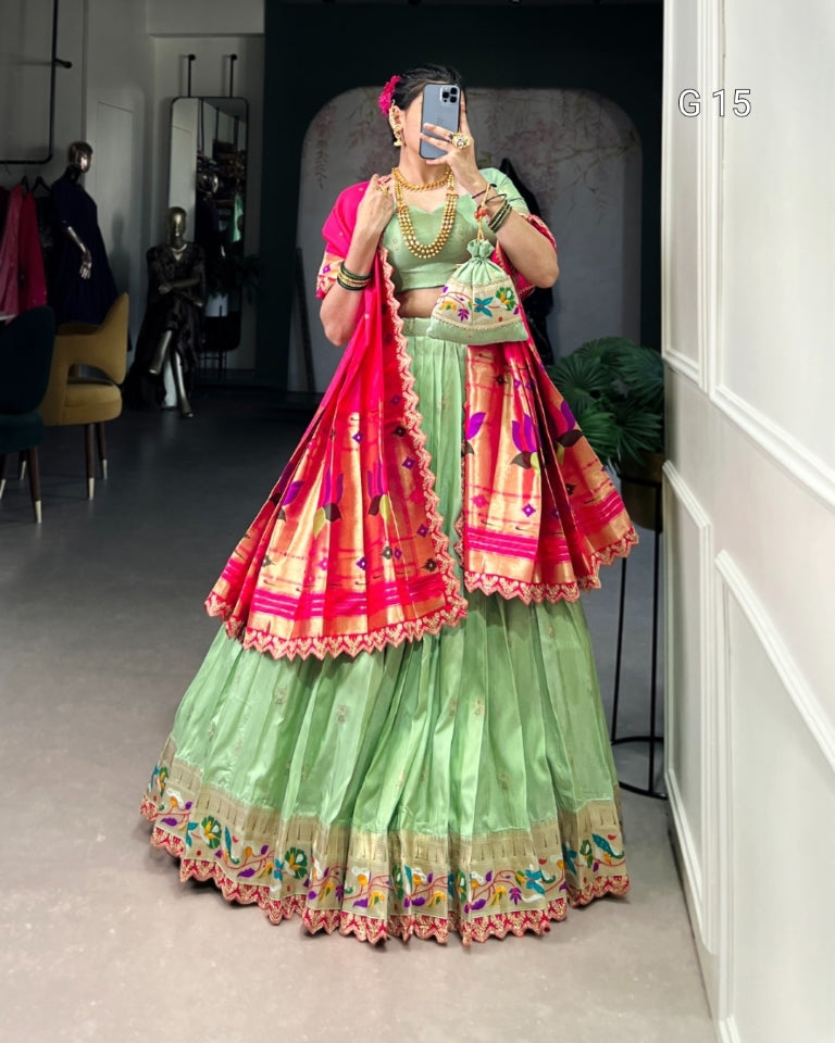 Person wearing a traditional green and pink outfit with floral patterns in a room.