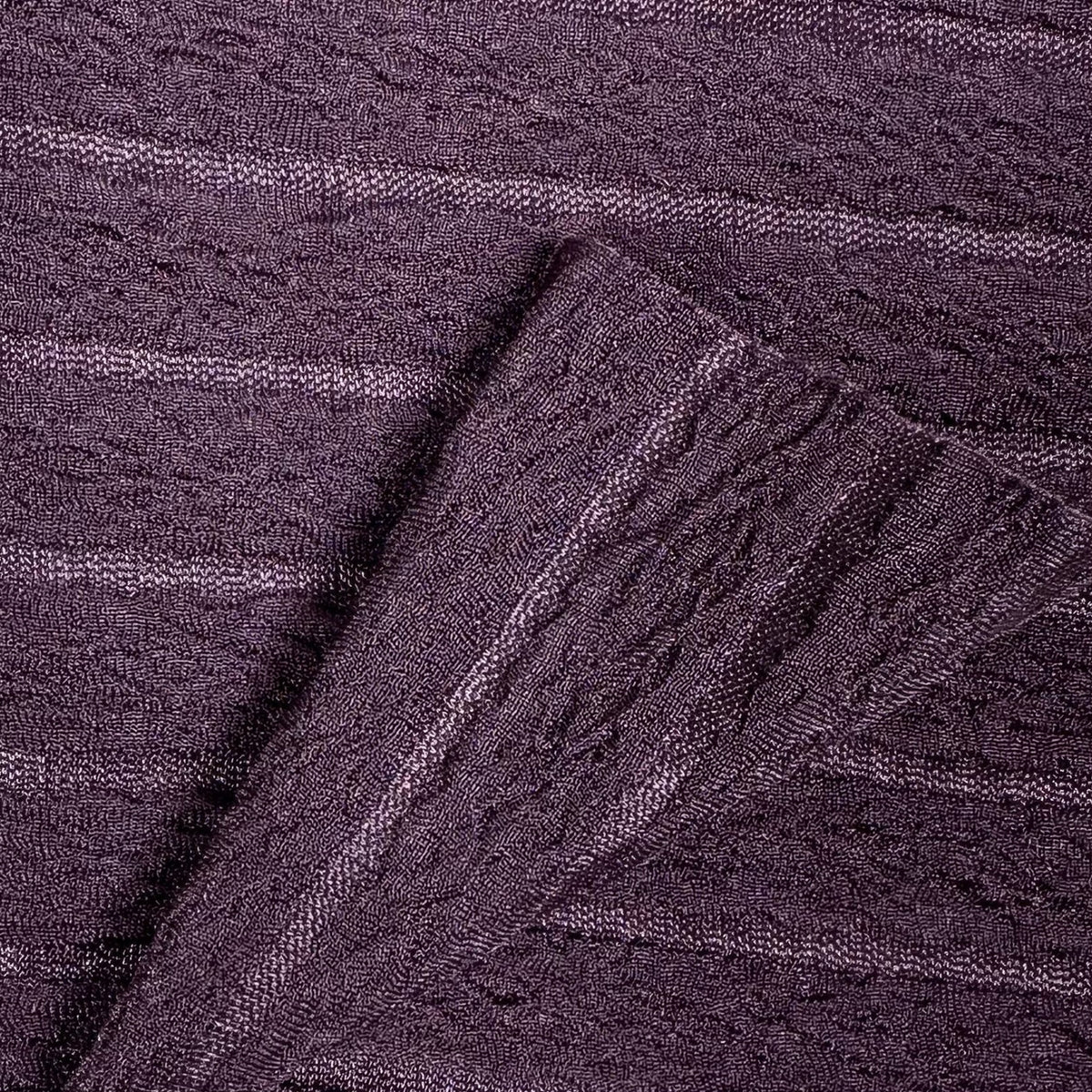 Close-up of purple textured fabric with a cable knit pattern