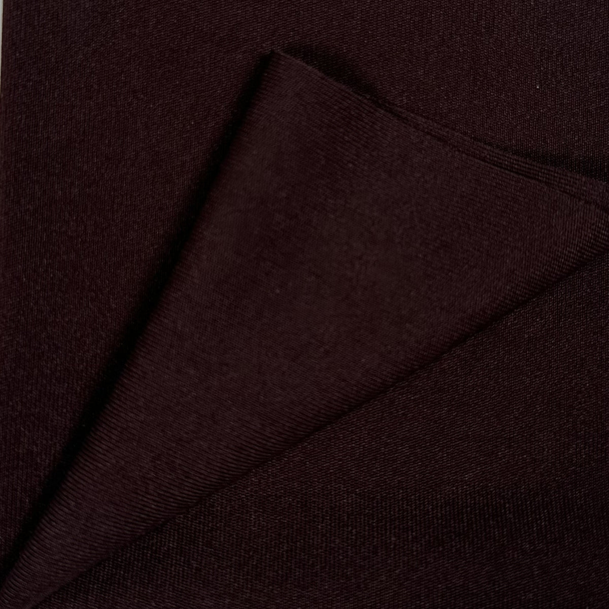 Close-up of dark brown fabric with a diagonal fold