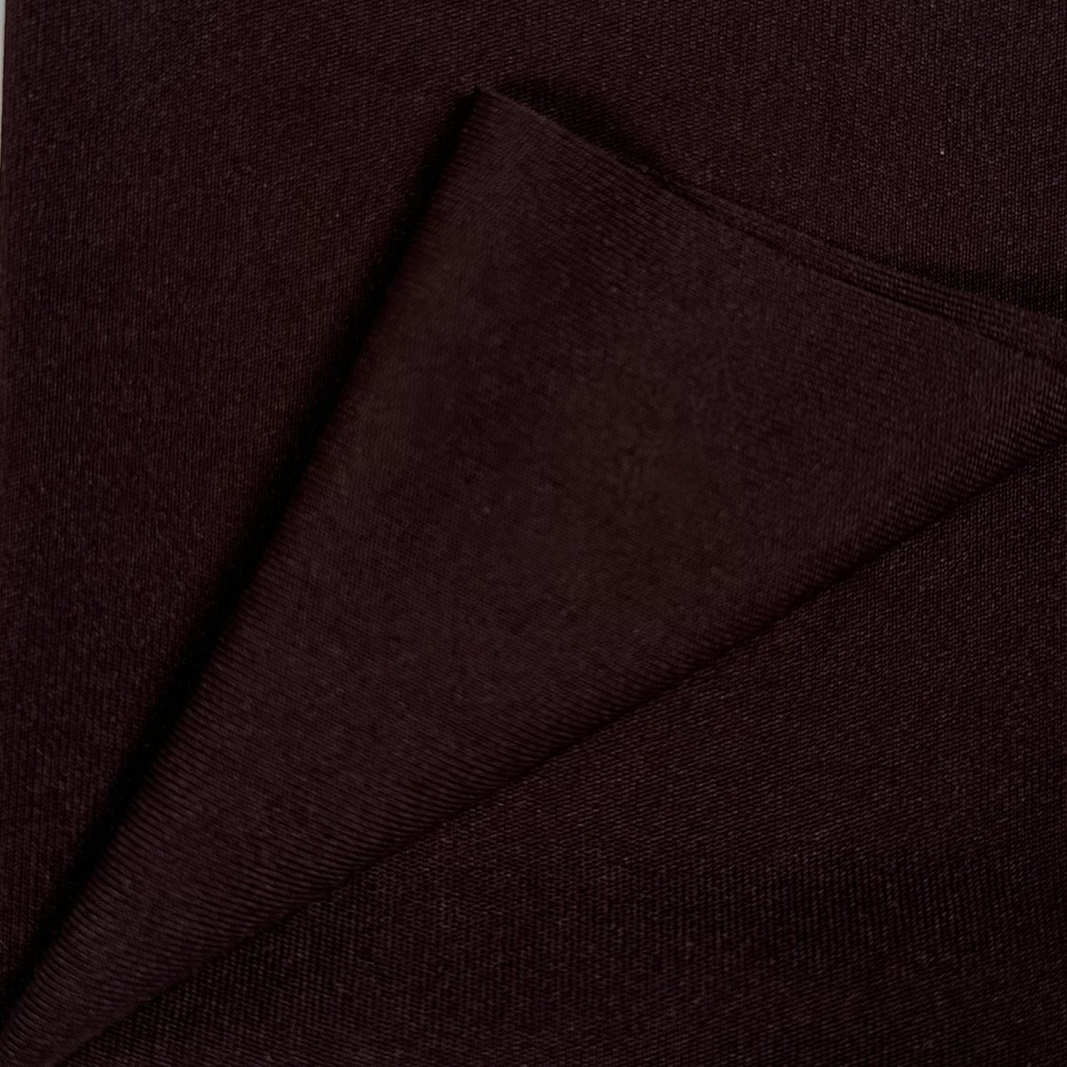 Close-up of dark brown fabric with a diagonal fold