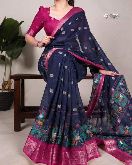 Woman wearing a blue saree with pink border, sitting on a chair.