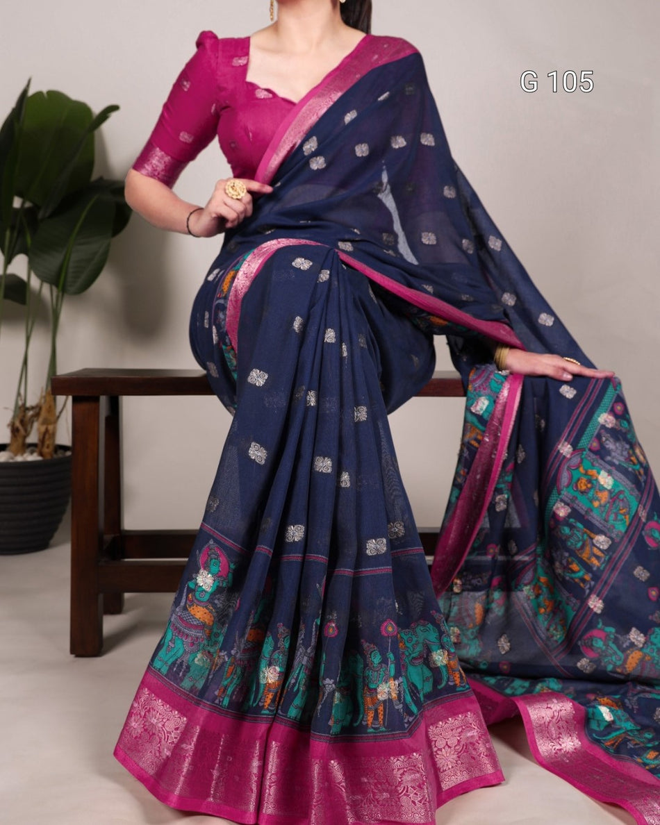 Woman wearing a blue saree with pink border, sitting on a chair.