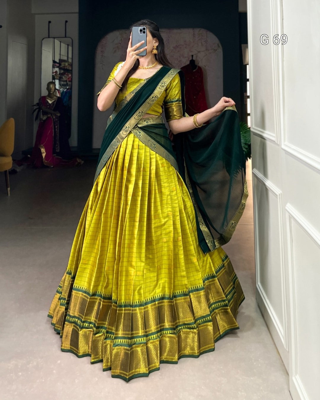 Person wearing a bright yellow and green traditional outfit indoors.