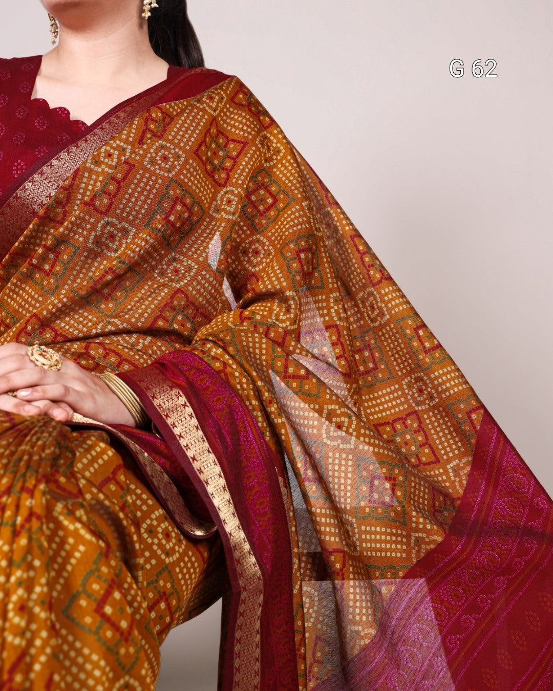 Saree with intricate patterns in gold and red on a plain background