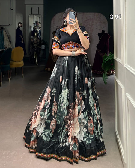 Woman wearing a black floral dress in a room with mirrors and furniture.