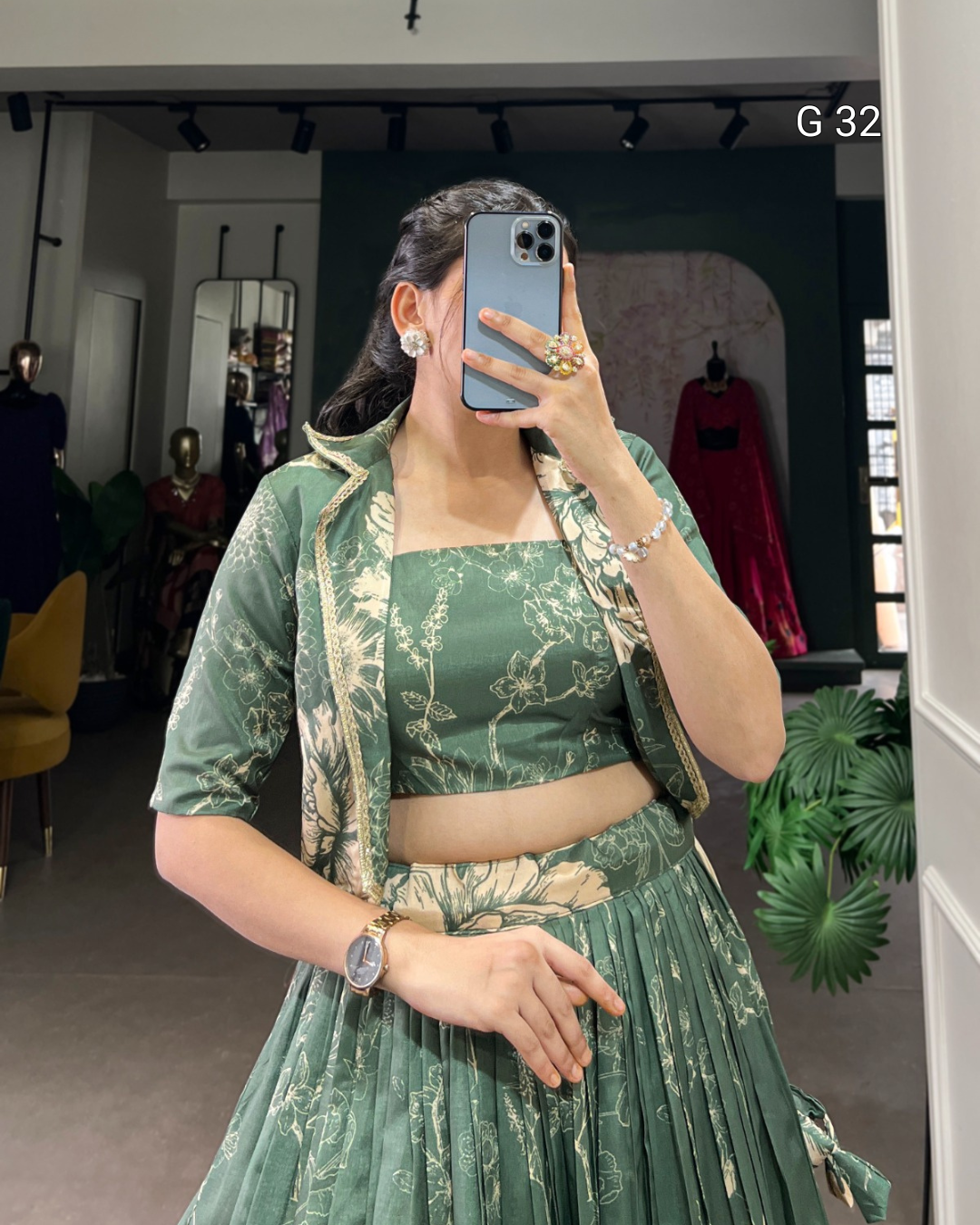 Person wearing a green traditional outfit with floral patterns in a store setting.