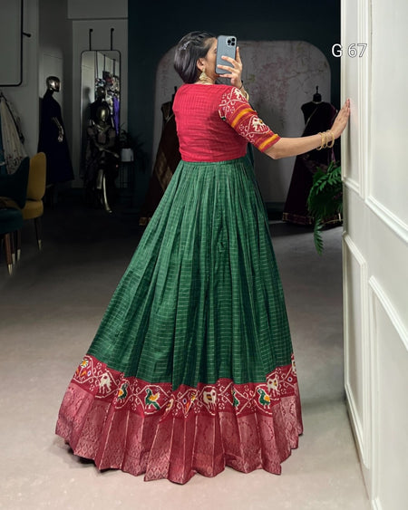 Person wearing a red and green traditional outfit taking a mirror selfie.