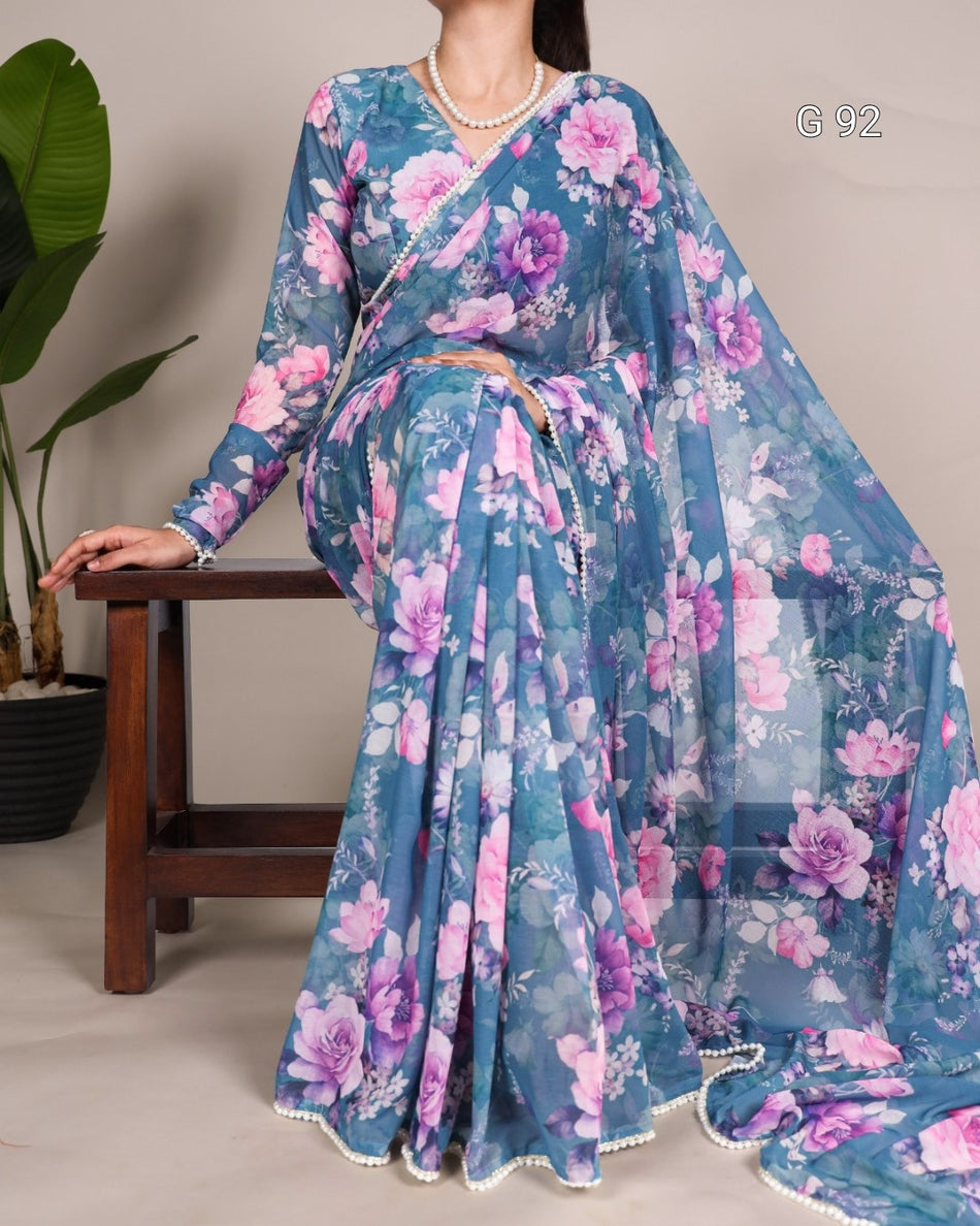 Woman wearing a blue floral saree with a plain background