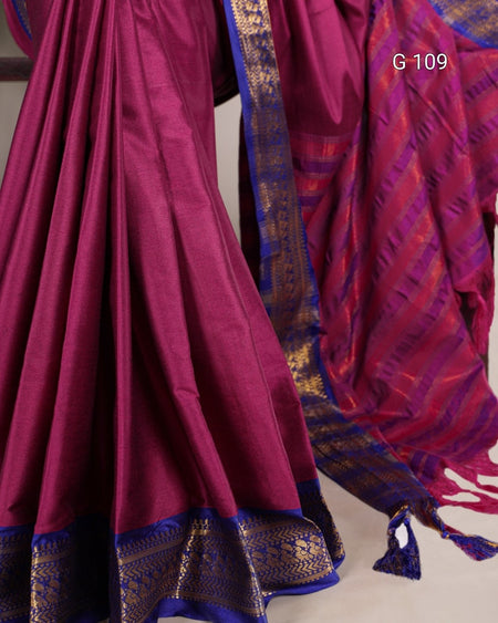 Magenta saree with gold and blue border on a plain background