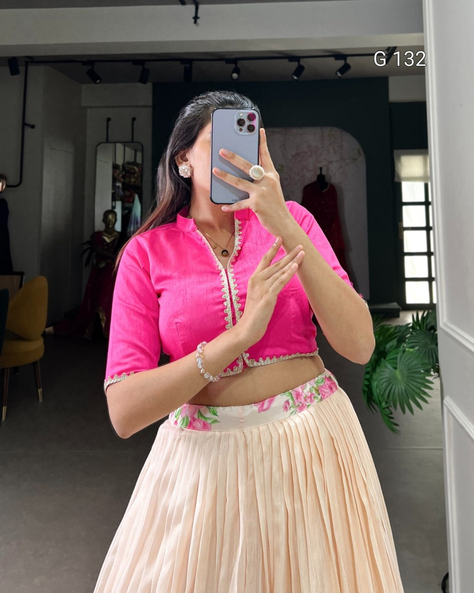 Woman taking a mirror selfie wearing a bright pink top and beige skirt with floral details.