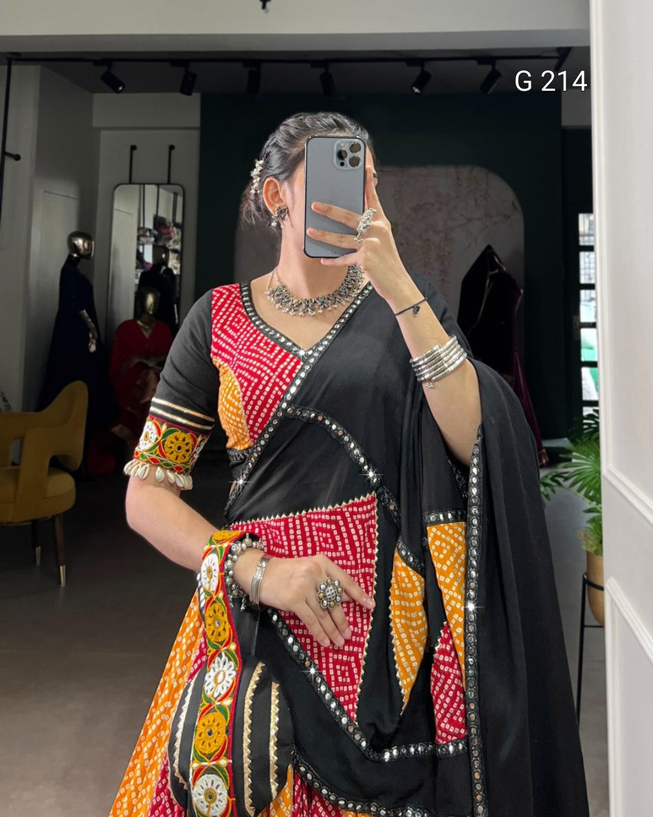 Person wearing a colorful saree with a patterned blouse, taking a mirror selfie.
