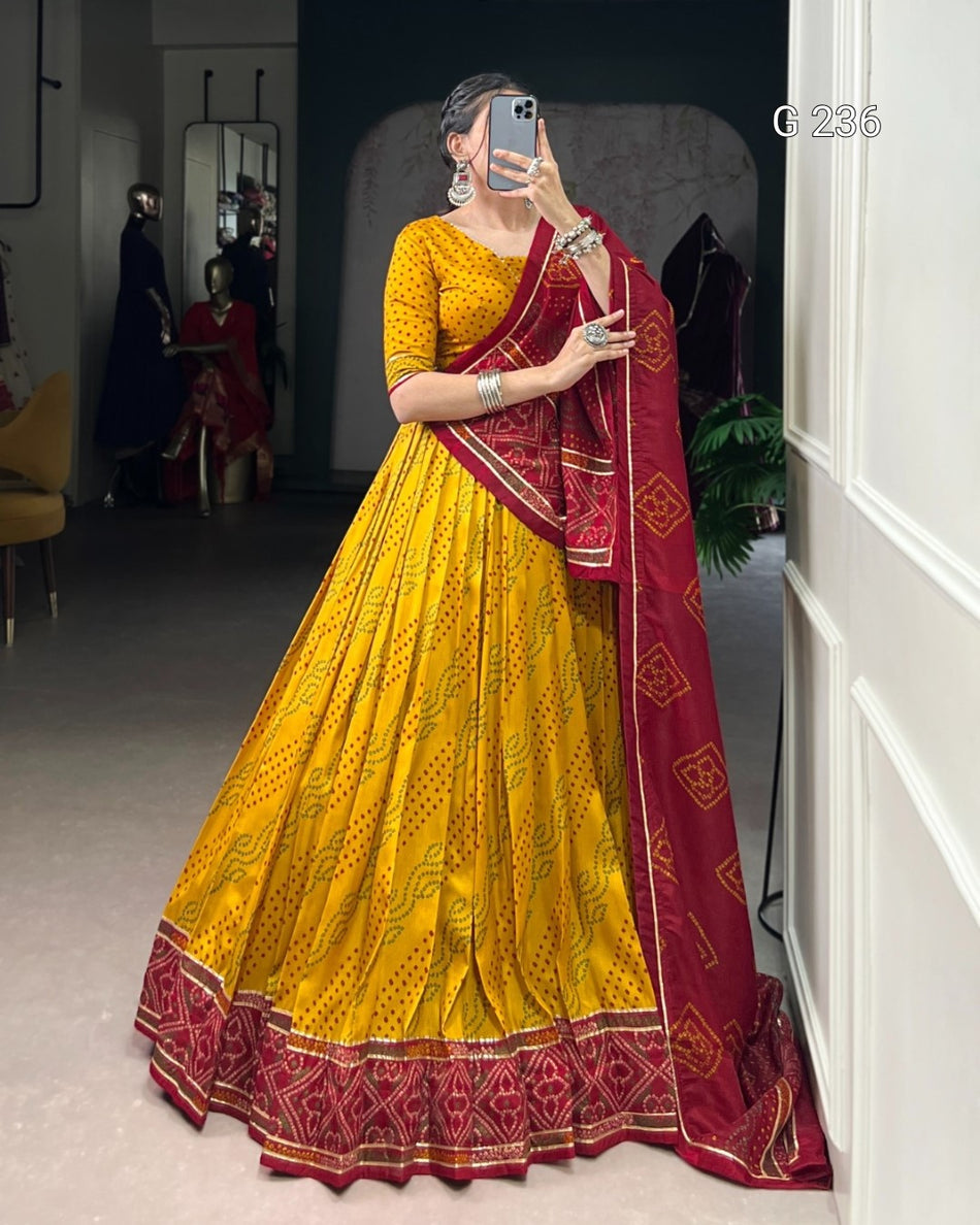 Woman wearing a yellow and red traditional outfit in a room.