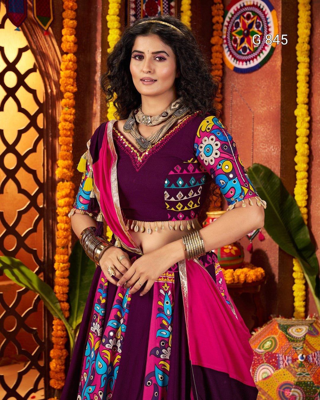Woman in a colorful traditional outfit with a decorative background