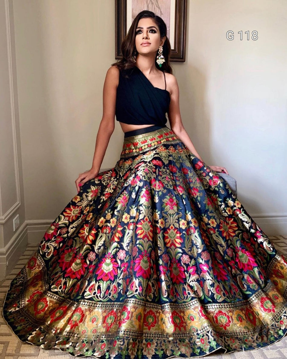 Woman wearing a traditional multicolored lehenga with a black top indoors.