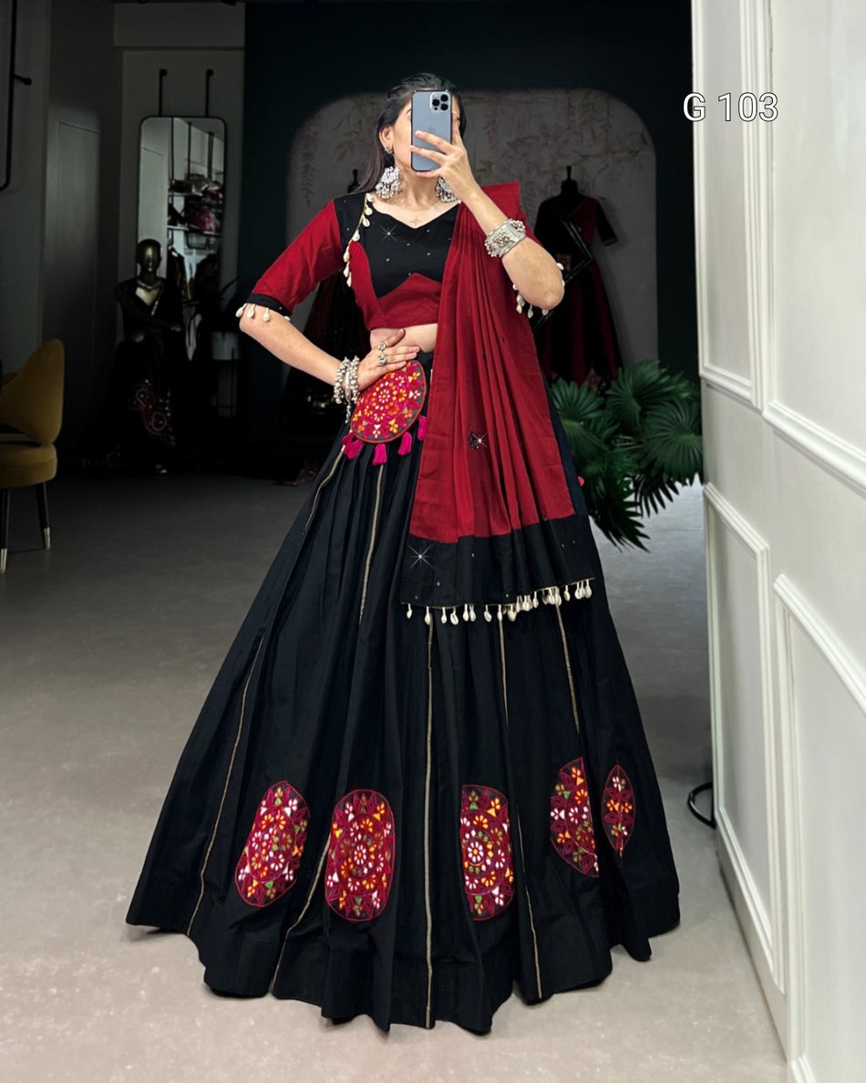 Woman wearing a black and red traditional outfit with floral patterns indoors.
