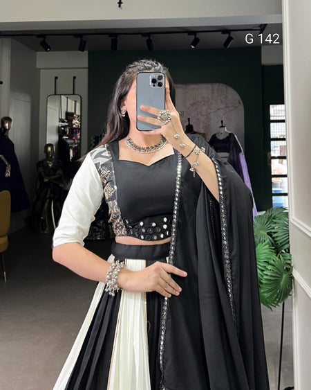 Woman taking a mirror selfie wearing a black and white traditional outfit with jewelry in a store setting.