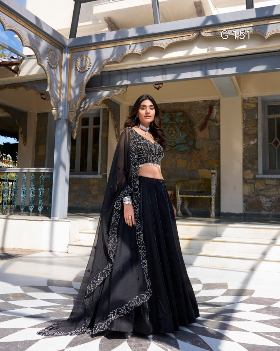 Woman in a black traditional outfit standing in front of a building with decorative architecture.