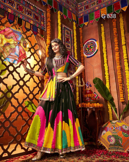 Woman in a colorful traditional outfit standing in a decorated room with vibrant decor.