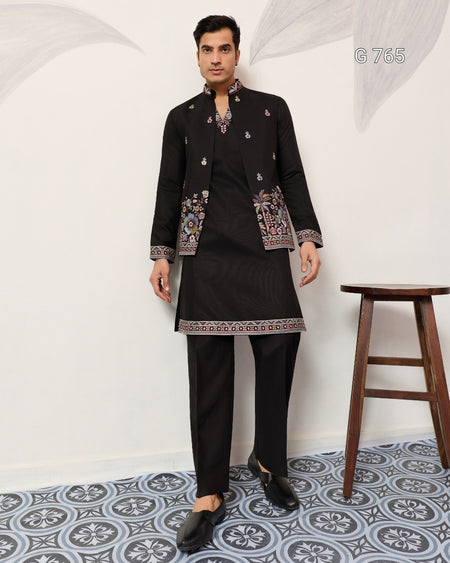 Man wearing a black traditional outfit with intricate patterns on a white background