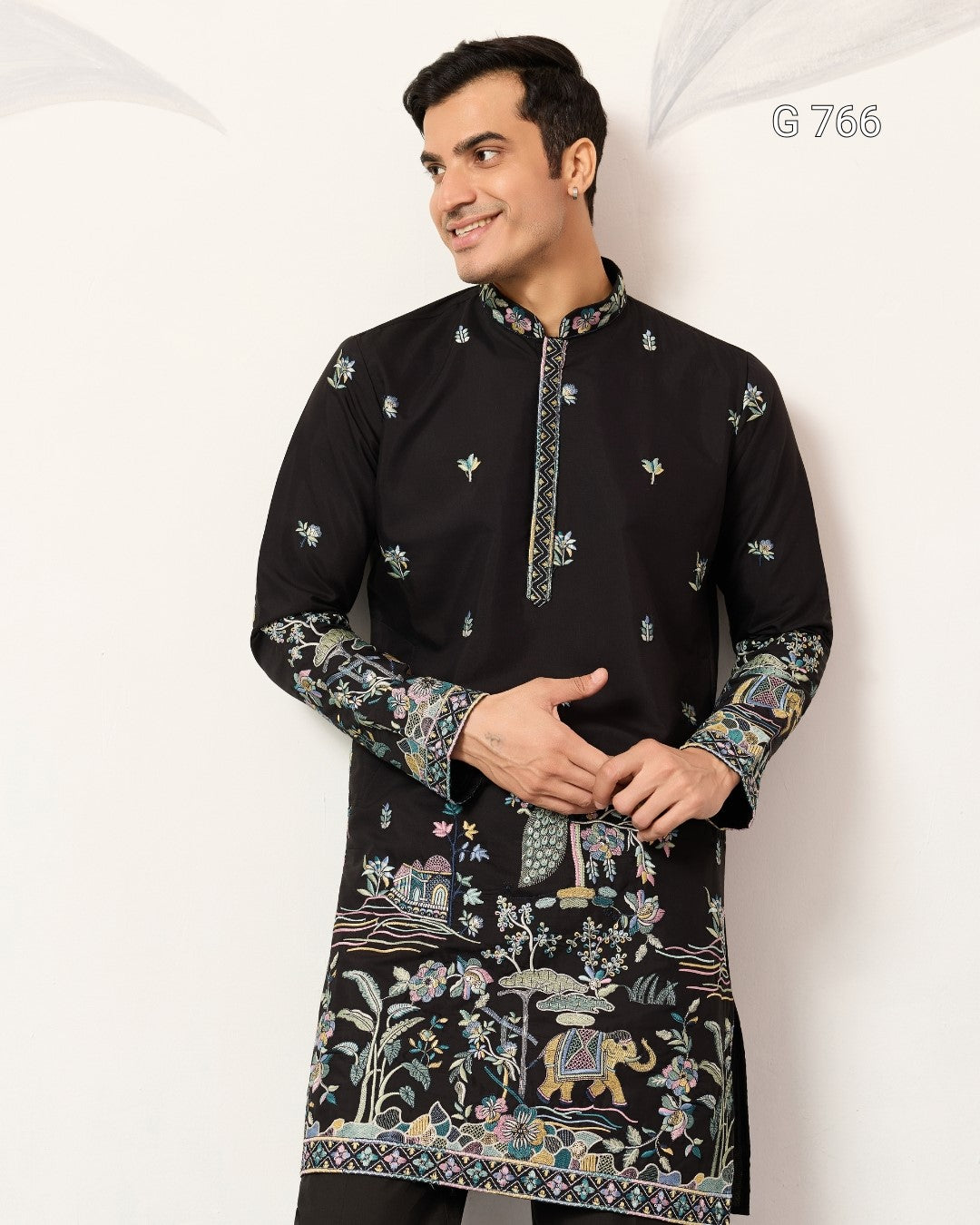 Man wearing a black embroidered kurta against a white background