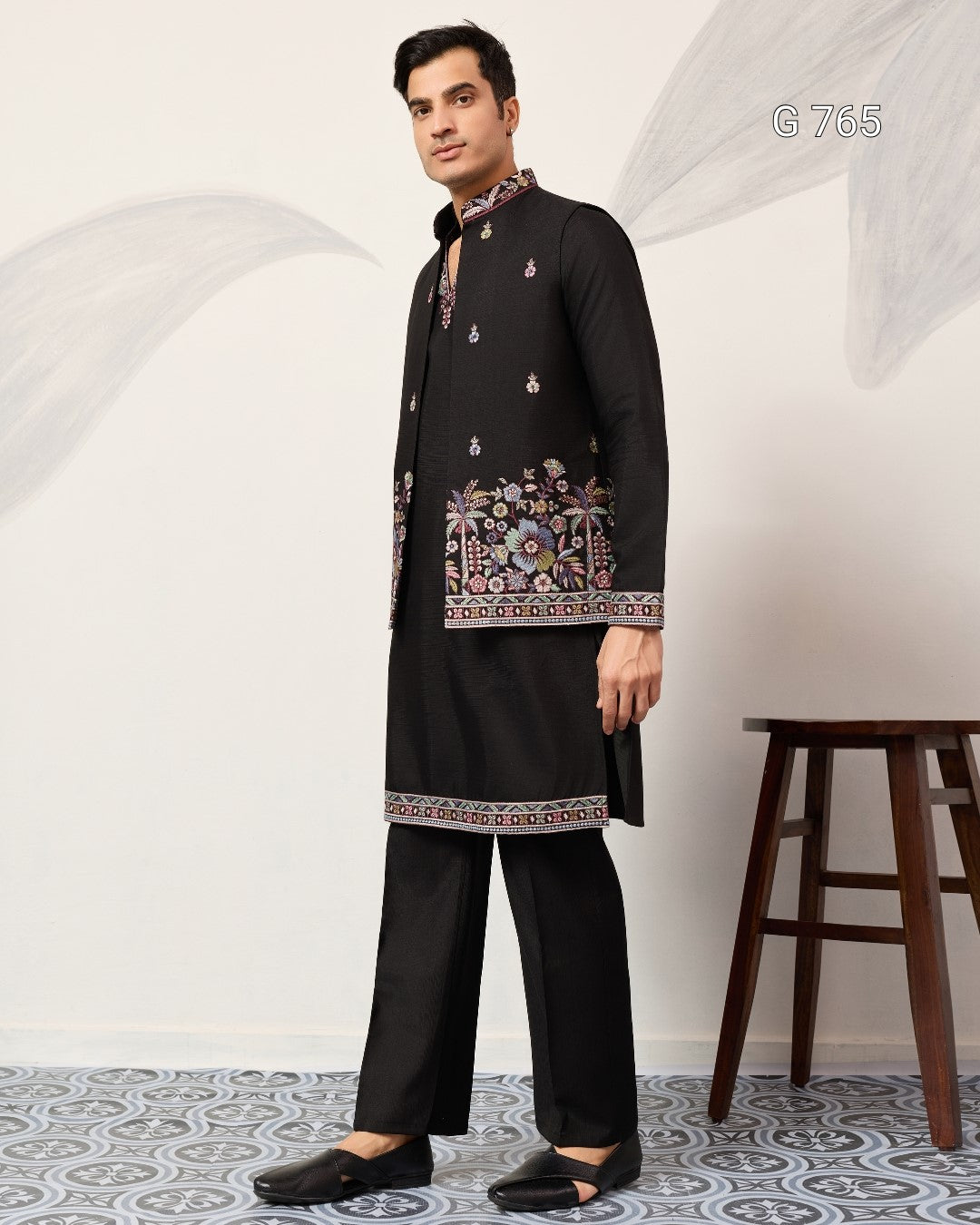 Man wearing a black embroidered kurta with pants in a minimalistic setting