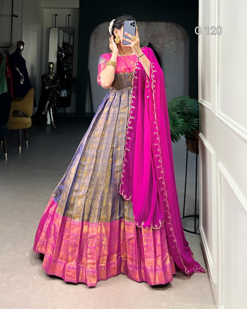 Person wearing a pink and purple traditional outfit with a matching dupatta in a room.