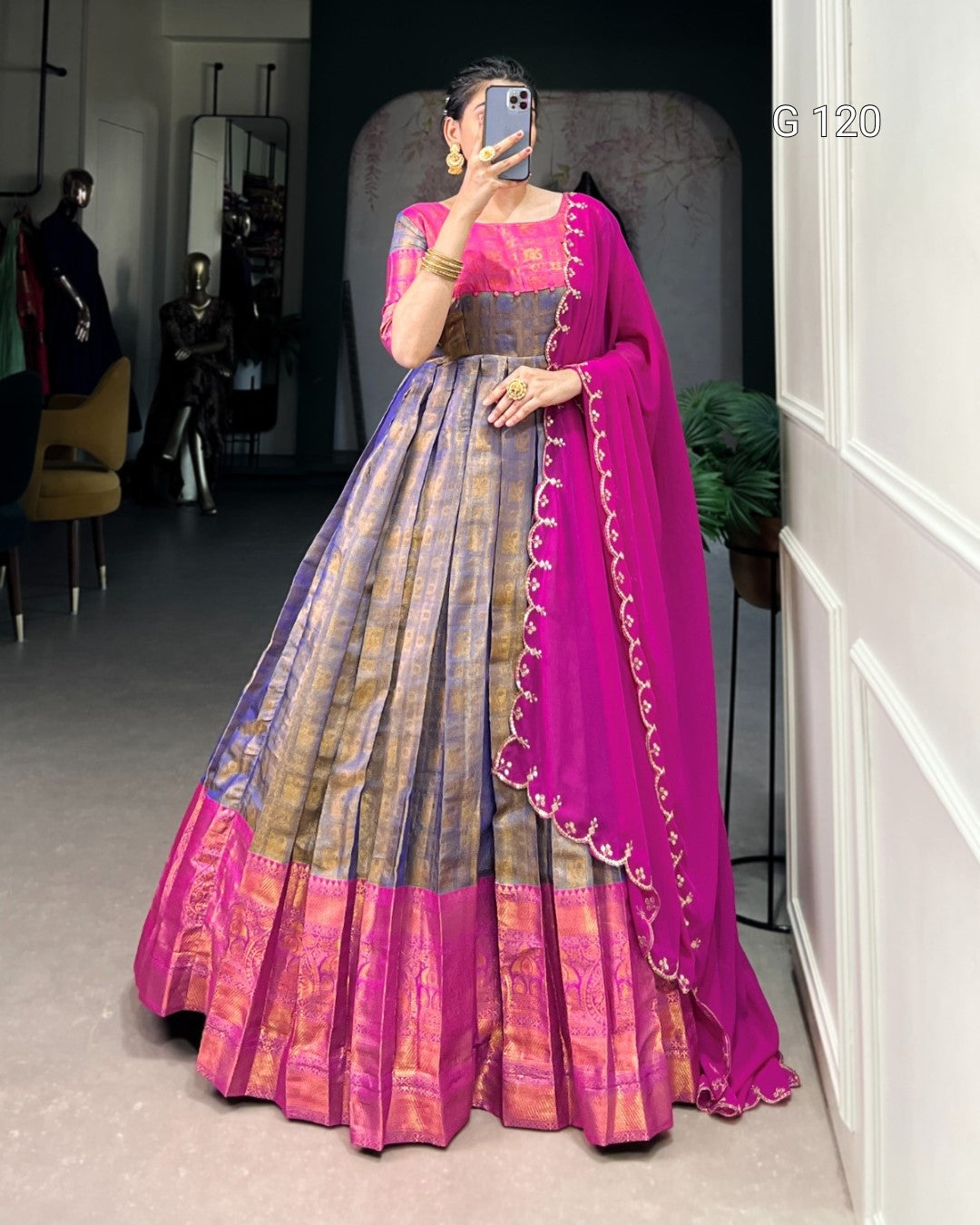 Person wearing a traditional outfit with a pink and purple saree in a room.