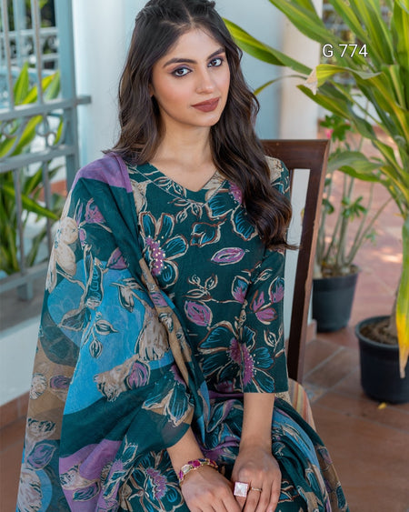 Woman wearing a floral dress with a colorful dupatta sitting outdoors.