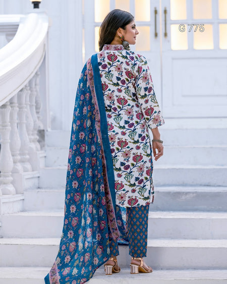 Woman in a floral outfit with a blue dupatta standing on white steps.
